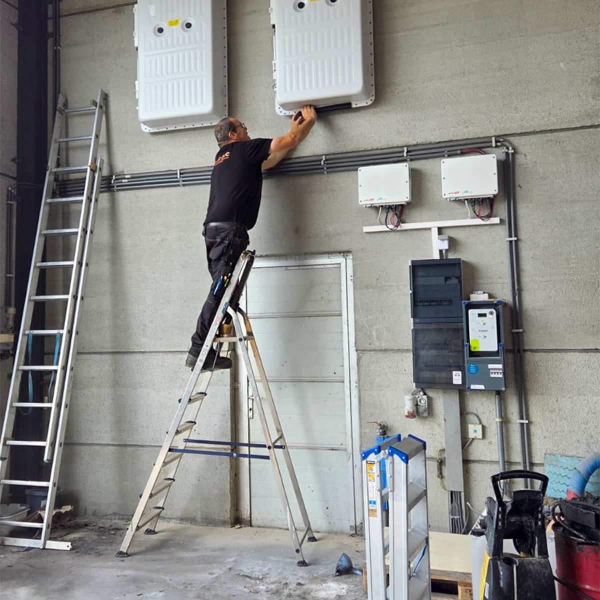 NRG-TEC-installateur die twee SolarEdge thuisbatterijen monteert bij een klant in Beernem.